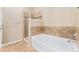 Bathroom showcasing a shower with glass door, a bathtub, and decorative tile accents at 9637 E 5Th Ave # 101, Denver, CO 80230