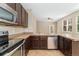 Open concept kitchen with stainless steel appliances, granite countertops, and dark cabinets at 9637 E 5Th Ave # 101, Denver, CO 80230