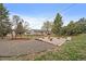 Large backyard featuring mature trees, a gravel area, and a built-in firepit at 31 Circle Dr, Castle Rock, CO 80104