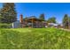 A sprawling backyard with a covered patio and mature trees at 10684 Downing St, Northglenn, CO 80233