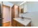 This well-lit bathroom features storage cabinet, vanity sink and views to a hallway at 10684 Downing St, Northglenn, CO 80233