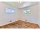 Bedroom with hardwood floors, baseboard heat, and two windows providing natural light at 10684 Downing St, Northglenn, CO 80233