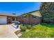 Charming brick home with green trim, lush lawn, and outdoor seating area at 10684 Downing St, Northglenn, CO 80233