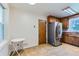 Functional kitchen with stainless steel refrigerator, wood cabinets, and tile flooring at 10684 Downing St, Northglenn, CO 80233