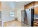 Traditional kitchen features wood cabinetry and updated stainless-steel refrigerator at 10684 Downing St, Northglenn, CO 80233