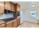 Traditional kitchen features wood cabinetry and black electric cooktop at 10684 Downing St, Northglenn, CO 80233