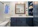 Charming bathroom with a blue vanity, custom storage, and modern lighting fixtures over the sink at 2308 Hearth Dr # 37, Evergreen, CO 80439