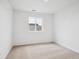 Bright bedroom with neutral carpet, white walls and a large window offering ample natural light at 45940 Gentry Ave, Bennett, CO 80102