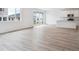 Sunlit living room with patio view and an attached kitchen with white cabinets at 45940 Gentry Ave, Bennett, CO 80102