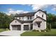 New two-story home boasts a three-car garage, white and brick facade, and well-maintained landscaping at 1696 Green Fern Pt, Castle Rock, CO 80104