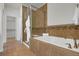 Luxurious bathroom with tile floors, soaking tub, glass enclosed shower, and stylish towel arrangement at 5887 S Taft Ln, Littleton, CO 80127