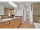 Bright bathroom featuring dual sinks, vanity with cabinets, tile backsplash, and glass enclosed shower at 5887 S Taft Ln, Littleton, CO 80127