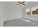 A carpeted bedroom with ceiling fan, two windows, and neutral decor at 5887 S Taft Ln, Littleton, CO 80127