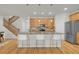 Modern kitchen featuring an island with bar seating, stainless steel appliances, and wood cabinets at 5887 S Taft Ln, Littleton, CO 80127