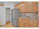 Bright kitchen featuring stainless steel refrigerator, wood cabinets, and ample counter space at 5887 S Taft Ln, Littleton, CO 80127