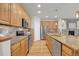 Well-lit kitchen with stainless steel appliances, tile backsplash, hardwood floors, and a large island at 5887 S Taft Ln, Littleton, CO 80127