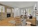 Bright living room featuring hardwood floors, a modern stone fireplace, and ample natural light at 5887 S Taft Ln, Littleton, CO 80127