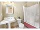 Bathroom featuring a pedestal sink, toilet, pink bathtub with white shower curtain and small green plant at 3042 N Franklin St, Denver, CO 80205