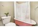 A bathroom featuring a vintage-style pink bathtub and a toilet with a decorative plant on top at 3042 N Franklin St, Denver, CO 80205