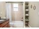 Bathroom featuring a shower-tub combination, a window and built in shelves with neatly folded towels at 3042 N Franklin St, Denver, CO 80205