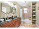 Bathroom featuring double sinks, wood vanity with black granite countertop, and shower-tub combination at 3042 N Franklin St, Denver, CO 80205