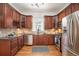 Kitchen with stainless steel appliances, wood cabinets, sleek countertops, tile backsplash and hardwood floors at 3042 N Franklin St, Denver, CO 80205