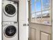 Stacked laundry machines next to a door with a window and view to the outside at 3042 N Franklin St, Denver, CO 80205