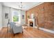 Inviting living room with hardwood floors, exposed brick wall, and cozy fireplace at 3042 N Franklin St, Denver, CO 80205