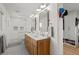 Bathroom with double vanity, marble countertops, and a tiled walk-in shower at 13438 W 23Rd Pl, Golden, CO 80401