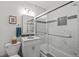 Bathroom featuring a shower-over-tub with glass doors, a marble accent wall, and sleek vanity at 13438 W 23Rd Pl, Golden, CO 80401