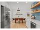 Bright dining room with a wood table, modern lighting, and floating shelves for decor and storage at 13438 W 23Rd Pl, Golden, CO 80401