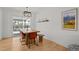 Bright dining room features a light fixture above a rustic table with orange chairs and a bench seat at 13438 W 23Rd Pl, Golden, CO 80401