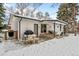 Back of the house with a patio, porch swing and outdoor furniture, all covered in snow at 13438 W 23Rd Pl, Golden, CO 80401