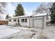 Well-maintained home with an attached garage, charming shutters, and a snow-covered driveway and front yard at 13438 W 23Rd Pl, Golden, CO 80401