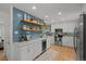 A bright, modern kitchen featuring blue backsplash tiles and plenty of white cabinets at 13438 W 23Rd Pl, Golden, CO 80401