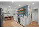 Kitchen with white cabinets, blue tile backsplash, open shelving, and a beverage cooler at 13438 W 23Rd Pl, Golden, CO 80401