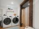 Bright laundry room with a farmhouse door, and modern washer and dryer at 13438 W 23Rd Pl, Golden, CO 80401