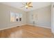 Bright bedroom features a ceiling fan, hardwood floors, and a large window with plantation shutters at 2552 E Alameda Ave # 104, Denver, CO 80209