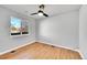 Simple bedroom with hardwood floors, neutral paint, a modern ceiling fan and two windows at 3200 Locust St, Denver, CO 80207