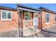 Welcoming front porch with brick facade and stylish black iron support post. Entry door marked 3209 at 3200 Locust St, Denver, CO 80207