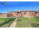 Charming brick home with a well-maintained front yard and inviting walkway under a clear, blue sky at 3200 Locust St, Denver, CO 80207