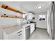 Modern kitchen featuring white cabinetry, quartz countertops, stainless steel appliances, and floating shelves at 3200 Locust St, Denver, CO 80207
