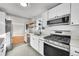Contemporary kitchen with stainless steel appliances, quartz countertops, open shelving, and white cabinets at 3200 Locust St, Denver, CO 80207