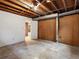 Unfinished basement area with exposed ceiling, concrete flooring, and wood paneling at 2433 S Oneida St, Denver, CO 80224