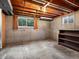 Unfinished basement with concrete walls, exposed wood ceiling, and small window at 2433 S Oneida St, Denver, CO 80224