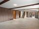 Partially finished basement with wood paneling, drop ceiling, and walkout door at 2433 S Oneida St, Denver, CO 80224