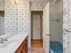 Bathroom featuring a single sink vanity, floral wallpaper, and bathtub at 2433 S Oneida St, Denver, CO 80224