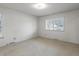 Bright bedroom with neutral carpet, minimalist wallpaper, and a large window at 2433 S Oneida St, Denver, CO 80224