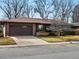 Well-maintained brick home with an attached garage and mature landscaping in the front yard at 2433 S Oneida St, Denver, CO 80224