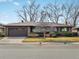 Charming brick home with a well-maintained front yard and mature trees on a sunny day at 2433 S Oneida St, Denver, CO 80224